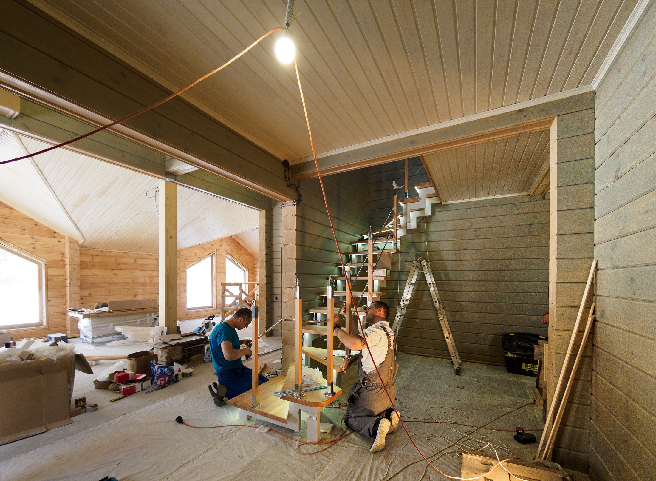 Carpenters building a wooden staircase during a home remodel
